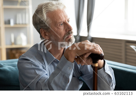 Unhappy old man with cane look in distance mourning Unhappy old man with cane look in distance mourning 63102113