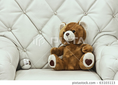 Christmas teddy bear on white leather chair. Christmas teddy bear on white leather chair. 63103113