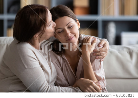Mature mother feeling happy after calming young daughter. 63103825