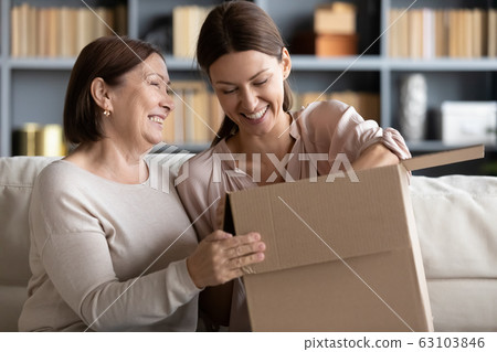 Excited family unboxing ordered goods from internet store. Excited family unboxing ordered goods from internet store. 63103846