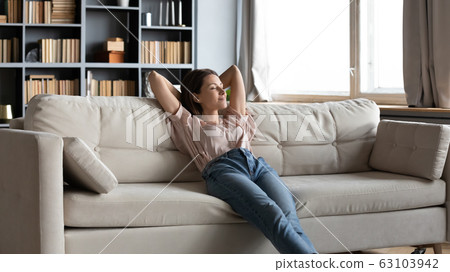 Calm happy sleepy woman relaxing on comfortable sofa. 63103942