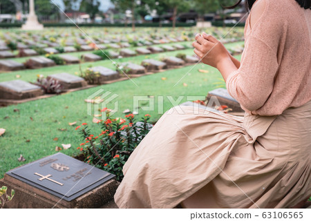 Close-Up of Religious Christian Woman Hands Clasped While Honoring and Praying to Military  63106565