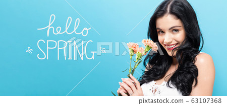 Hello spring message with young woman holding carnations Hello spring message with young woman holding carnations 63107368