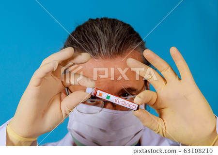 Hand of a doctor holding a bottle of blood sample Hand of a doctor holding a bottle of blood sample 63108210