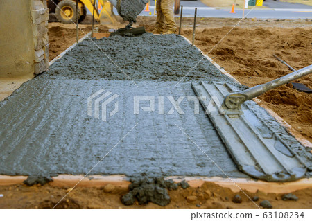 Mason building a screed coat cement at floor work. Mason building a screed coat cement at floor work. 63108234