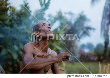 Old man smokes cigarettes. Old man smokes cigarettes. 63108943