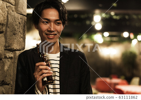 Young man (beer, night, drinking out, outdoor Young man (beer, night, drinking out, outdoor 63111862