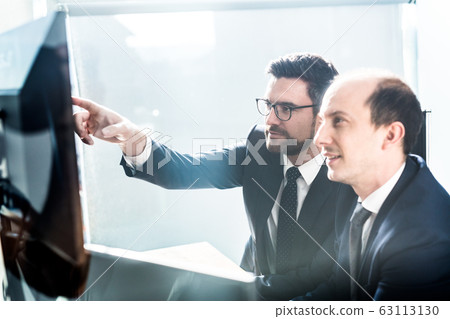 Business team analyzing data at business meeting in modern corporate office. Business team analyzing data at business meeting in modern corporate office. 63113130