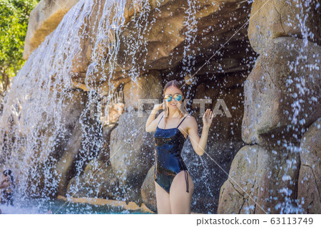 Young joyful woman under the water stream, pool, day spa, hot springs Young joyful woman under the water stream, pool, day spa, hot springs 63113749