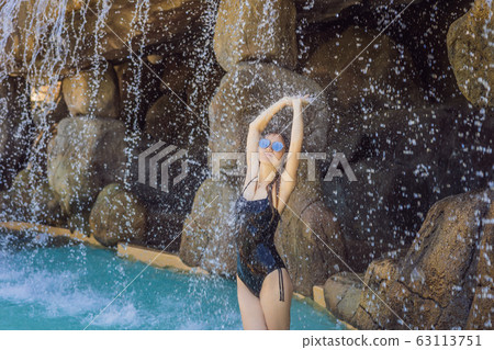 Young joyful woman under the water stream, pool, day spa, hot springs Young joyful woman under the water stream, pool, day spa, hot springs 63113751