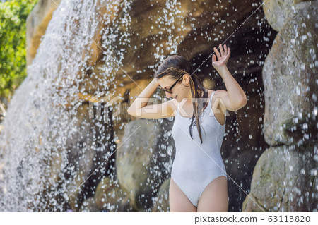 Young joyful woman under the water stream, pool, day spa, hot springs Young joyful woman under the water stream, pool, day spa, hot springs 63113820
