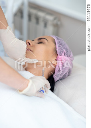 Woman having injection in neck while having anti-aging procedures Woman having injection in neck while having anti-aging procedures 63115676