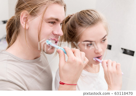 Young couple in bath brush teeth together, looking in mirror. Close-up 63118470