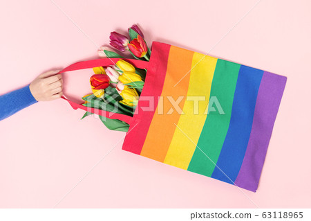 LGBTQ pride rainbow flag tote bag in a hand LGBTQ pride rainbow flag tote bag in a hand 63118965