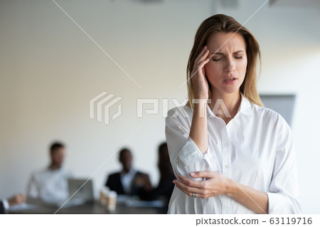 Stressed young female office worker suffering from high blood pressure. 63119716