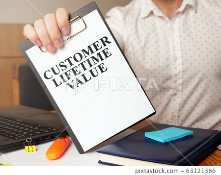 Man is holding Customer lifetime value report. Man is holding Customer lifetime value report. 63121366