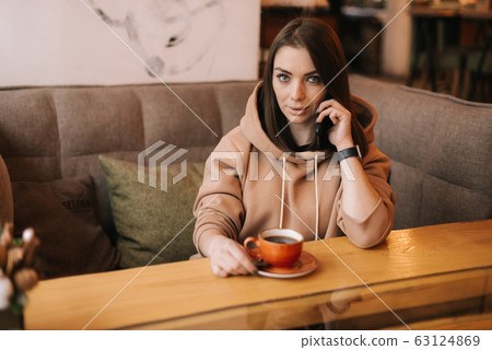 Portrait of handsome young woman in casual clothes talking on the phone Portrait of handsome young woman in casual clothes talking on the phone 63124869