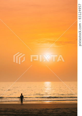 Silhouette Of Young Caucasian Lady Woman In Swimsuit Walking In Sea Beach During Sunset. Vacation On Ocean Beach. Sundown Above Sea Horizon At Sunset. Natural Sunrise Sky Warm Colors Over Ocean 63124957