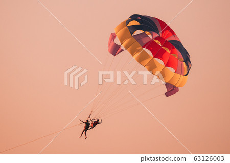 Parasailers Flying On Colorful Parachute In Sunset Or Sunrise Sky. Active Hobby 63126003