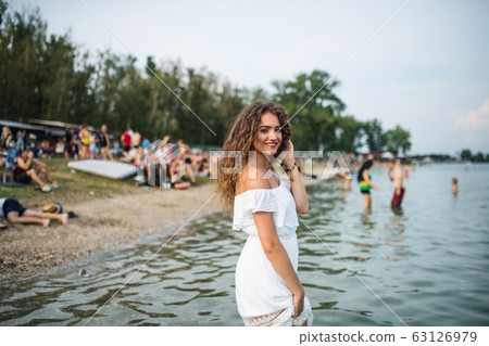 Young woman at summer festival, standing in lake. Young woman at summer festival, standing in lake. 63126979