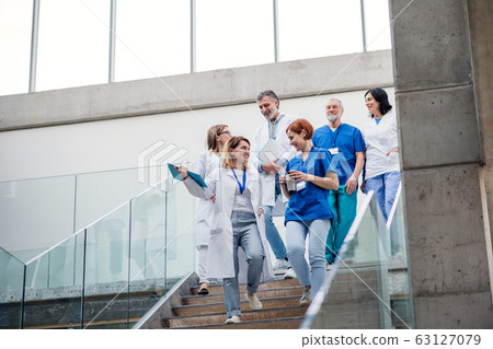 Group of doctors walking down stairs on medical conference. 63127079