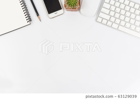 Top view of working desk white with smartphone, computer and office supplies Top view of working desk white with smartphone, computer and office supplies 63129039