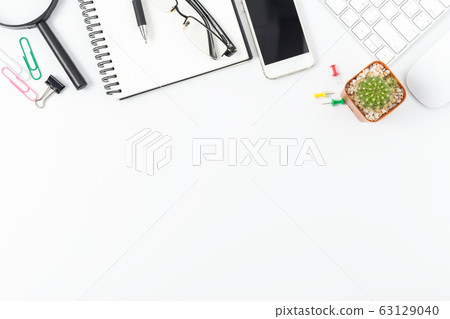 office desk with smartphone, computer and office supplies top view office desk with smartphone, computer and office supplies top view 63129040