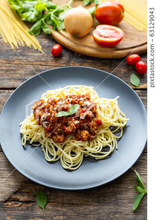 Spaghetti on black plate on wooden background. top view Spaghetti on black plate on wooden background. top view 63129043