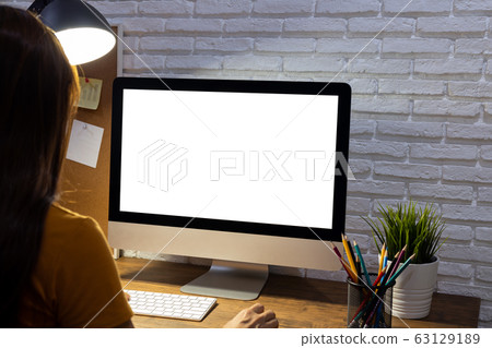 woman working empty screen computer mockup on wood desk in office. woman working empty screen computer mockup on wood desk in office. 63129189