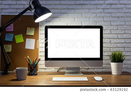 workspace with computer with blank white screen mockup, and office supplies on a wooden desk workspace with computer with blank white screen mockup, and office supplies on a wooden desk 63129192