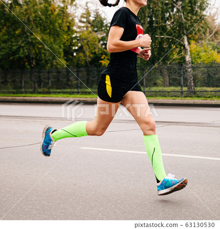 female athlete in compression socks running 63130530