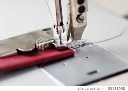 A leather craftsman produces leather goods on a 63131068