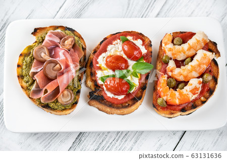 Italian buschettas with different toppings 63131636