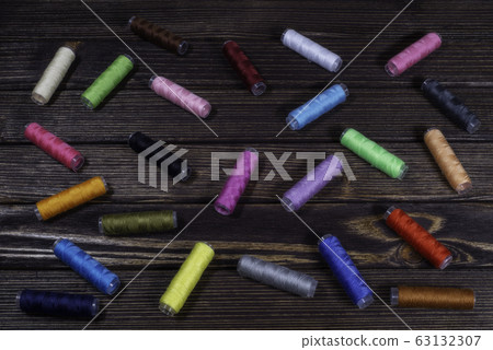 Group of differently colored spools perching Group of differently colored spools perching 63132307