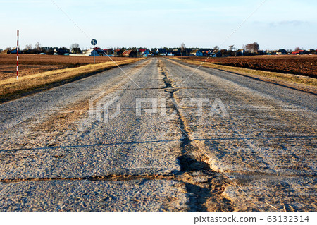 Dangerous asphalt road with holes destroyed. Dangerous asphalt road with holes destroyed. 63132314
