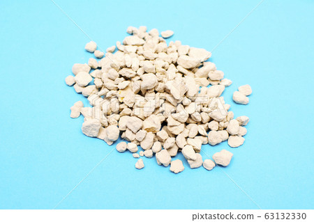 Zeolite mineral stone, zeolite pebbles isolated of blue background. Zeolite mineral stone, zeolite pebbles isolated of blue background. 63132330