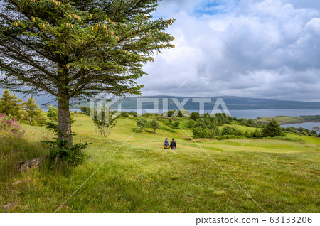 Tourist's couple walking at Islanf of Mull fields Tourist's couple walking at Islanf of Mull fields 63133206