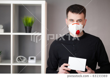 Man working in the office wearing a mask for protection from coronavirus 63133369