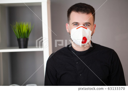 Man working in the office wearing a mask for protection from coronavirus 63133370