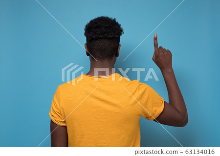 Back view of pointing up blackman. gesticulating showing on copyspace. 63134016