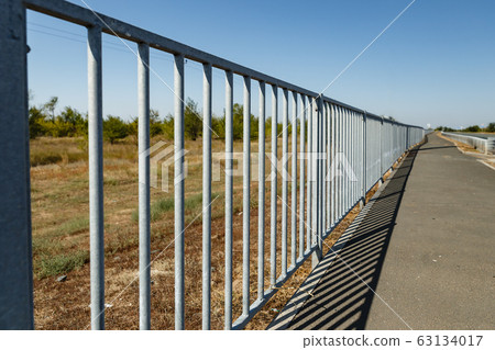 fence between the field and the pedestrian walkway 63134017