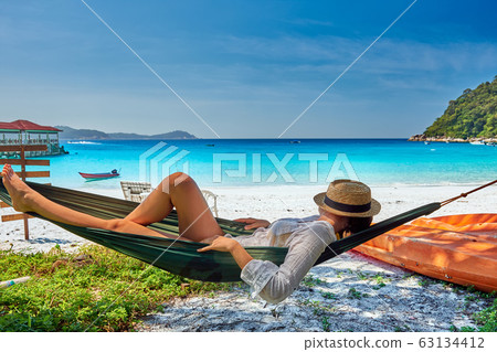 Woman in hammock on beach 63134412