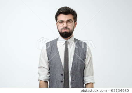 Young man looking camera puffing out cheeks from resentment. Young man looking camera puffing out cheeks from resentment. 63134980