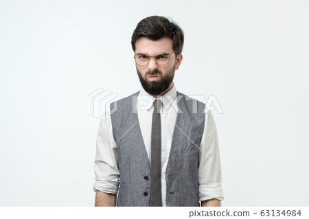 Angry irritated young man looking camera being displeased with news. Angry irritated young man looking camera being displeased with news. 63134984