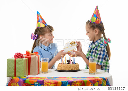 A girl gives a gift to her friend at the holiday A girl gives a gift to her friend at the holiday 63135127