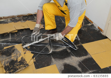 Old vinyl tiles removal from floor in a room or 63135693