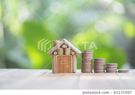 a row of coins and a small house model on the a row of coins and a small house model on the 63135997