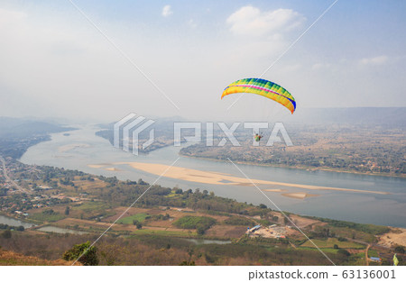Paragliding in the sky. Paraglider flying over Paragliding in the sky. Paraglider flying over 63136001