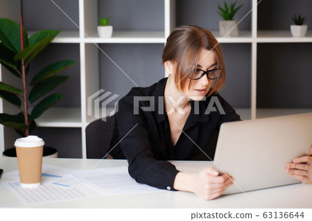 Tired woman working at the computer in the office Tired woman working at the computer in the office 63136644