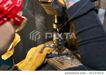 female artisan works on a drilling machine with a female artisan works on a drilling machine with a 63137018